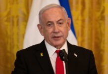 Netanyahu’s Buffer Zone Strategy Faces Global Criticism A government official speaking at a podium with a microphone