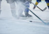 Ice hockey players competing on the rink with a puck in play