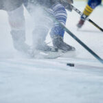 Ice hockey players competing on the rink with a puck in play