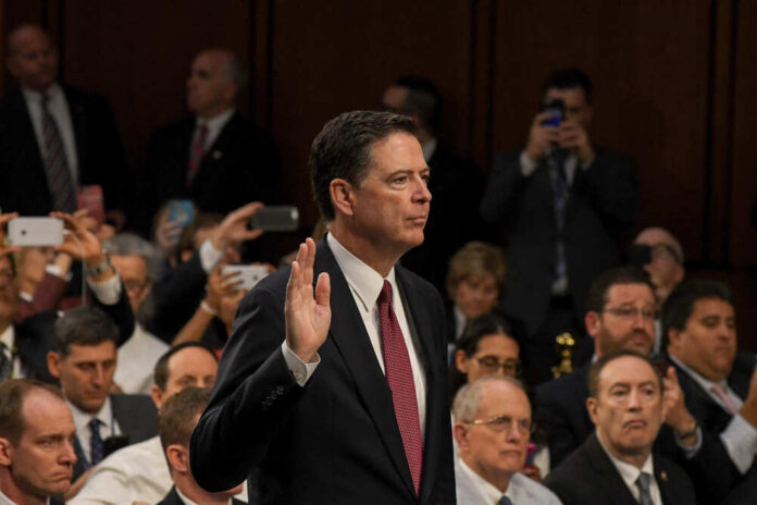 A man raising his right hand during a congressional hearing