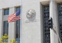United States courthouse facade with American flag at half-mast