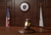 Ethics Bombshell Upends Georgia Election Fight A wooden gavel resting on a table in a courtroom with flags in the background