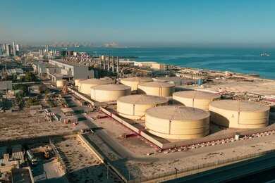 shutterstock_1859033734-1 Aerial view of large oil storage tanks near a coastal area