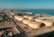Aerial view of large oil storage tanks near a coastal area