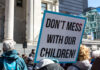 A protester holding a sign that reads 'DON'T MESS WITH OUR CHILDREN!'
