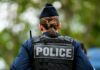 Gruesome Belfast Attack Sparks Border Uproar Back view of a police officer wearing a uniform and a police vest