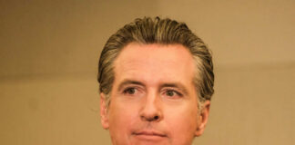 A man in business attire with a serious expression, captured in a medium shot