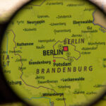 Close-up view of a map showing Berlin and Brandenburg under a magnifying glass