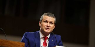 Man in a blue suit speaking at a government hearing