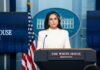 Declassified Files Ignite Biolab Firestorm Woman in white suit speaking at White House press podium