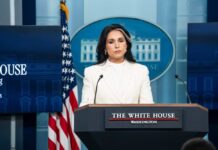 Declassified Files Ignite Biolab Firestorm Woman in white suit speaking at White House press podium
