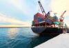 Iran Heroin Pipeline Exposed in Poland Cargo ship loaded with colorful shipping containers at a dock