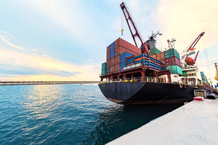 Container,Ship,Commercial,Vessel,Alongside,In,Port,For,Loading,And Cargo ship loaded with colorful shipping containers at a dock