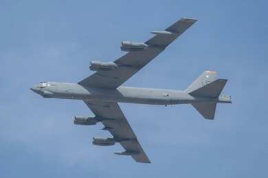 Military bomber aircraft flying against a blue sky