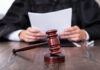 Federal Hammer Hits Trump — $5M Stands A judge holding documents with a gavel in the foreground