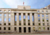 Spyware Titans Dragged Into Court Facade of a government building with the words Law and Justice and a statue on top