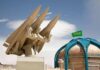 missile launcher beside domed building with green flag