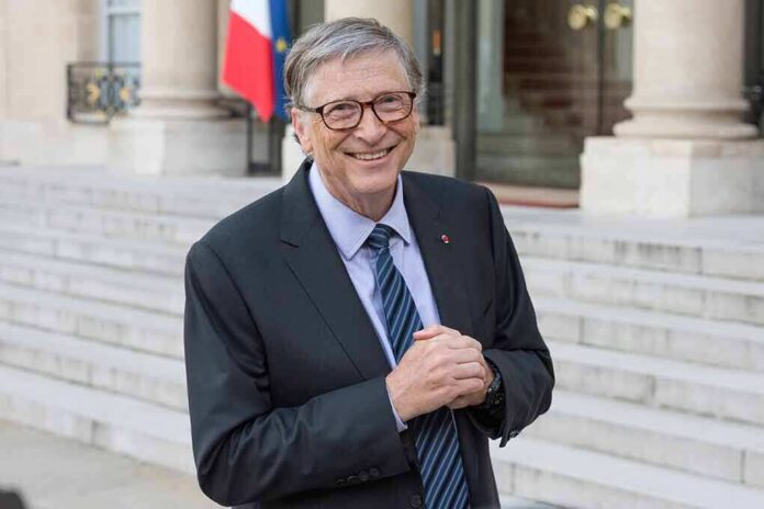 smiling older man in a suit standing on stone steps