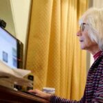 older woman using a desktop computer at a desk