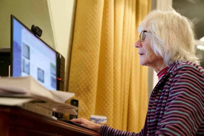 shutterstock_1229155285 older woman using a desktop computer at a desk