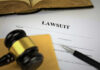 Hacked Files Ignite MSG–Wired Brawl A gavel resting on a legal document titled 'LAWSUIT' with a pen and an open book in the background
