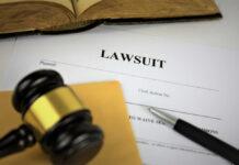 Hacked Files Ignite MSG–Wired Brawl A gavel resting on a legal document titled 'LAWSUIT' with a pen and an open book in the background