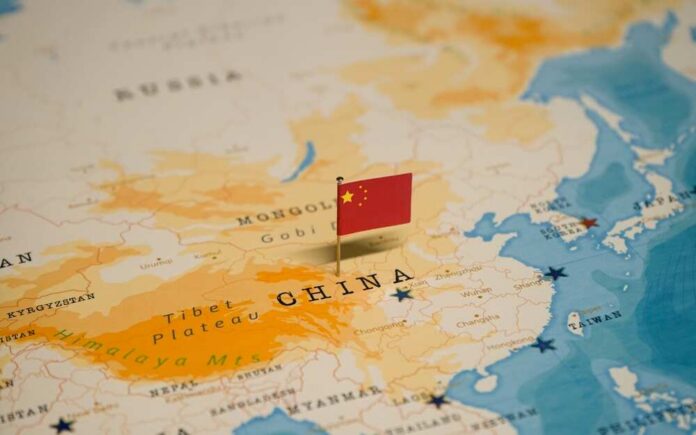 The,Map,And,Flag,Of,China. Map of China with a small Chinese flag placed on it