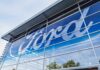 EV Dream Dies: Ford Slams the Brakes Exterior view of a Ford dealership with a large logo on the glass