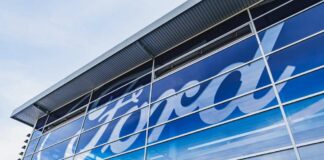 Exterior view of a Ford dealership with a large logo on the glass