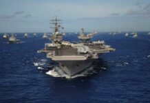 War Games Keep ‘Sinking’ U.S. Carriers An aircraft carrier surrounded by various naval ships in the ocean