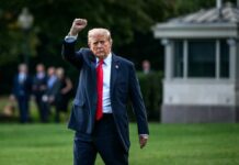 USA Chants Erupt — Then Comes The Split A political figure walking outdoors with a raised fist