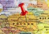 Red pushpin marking Poland on a European map