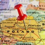 Red pushpin marking Poland on a European map
