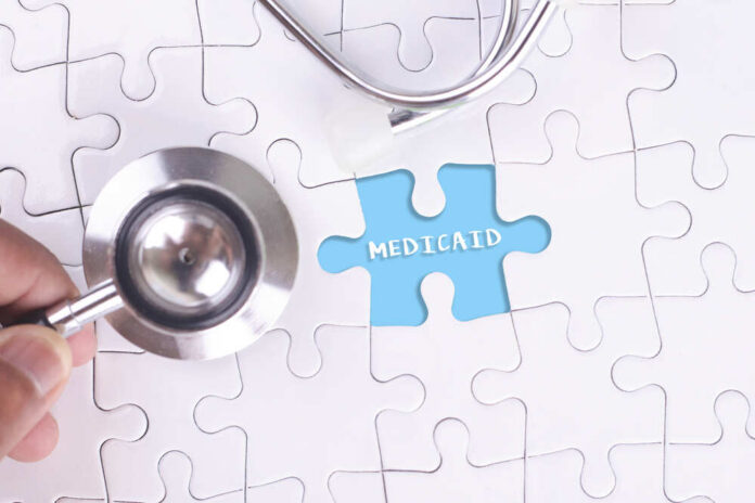 A,Doctor,Holding,A,Stethoscope,On,Missing,Puzzle,With,Medicaid A stethoscope next to a puzzle piece labeled 'Medicaid'