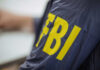 Bipartisan Firestorm Erupts Over DOJ Raid Close-up of an FBI agents jacket with yellow lettering