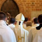 Bishop in white mitre among clergy during church procession