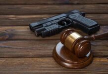 Gavel and handgun on wooden table