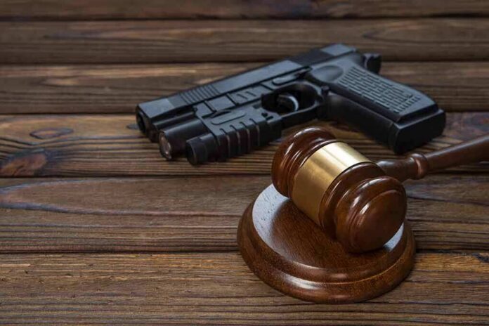 shutterstock_1021395283 Gavel and handgun on wooden table