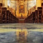 Church interior with wooden pews facing ornate altar