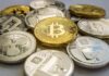 Stack of assorted cryptocurrency coins with a gold bitcoin in the center