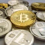 Stack of assorted cryptocurrency coins with a gold bitcoin in the center