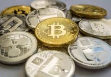 Stack of assorted cryptocurrency coins with a gold bitcoin in the center