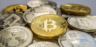 Stack of assorted cryptocurrency coins with a gold bitcoin in the center