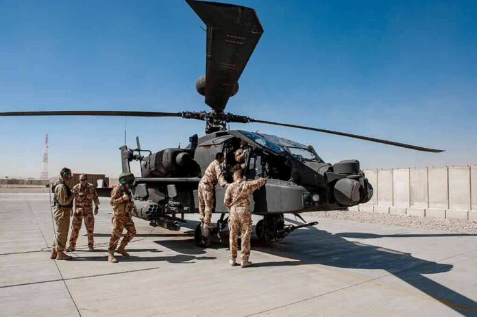 Soldiers inspect a military attack helicopter on a tarmac