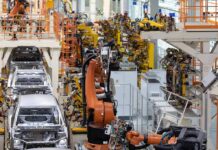 Trump Boom Talk Collides With Payroll Pain Industrial robots assemble car bodies on an automotive production line