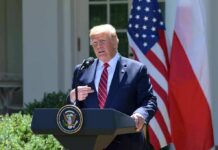 man at presidential podium speaking outdoors