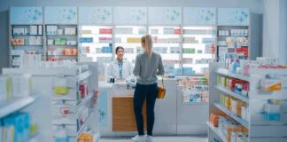 Customer at pharmacy counter speaking with pharmacist