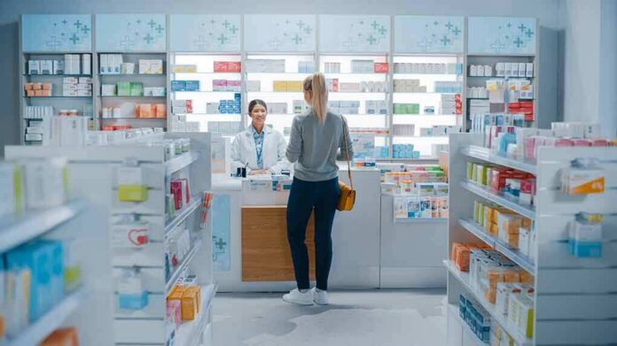 shutterstock_1952231947 Customer at pharmacy counter speaking with pharmacist