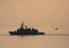 Iran Blinks? Surprise Hormuz Deal Brewing naval ship silhouette at sea during sunset