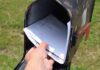Hand retrieving mail from an open rural mailbox